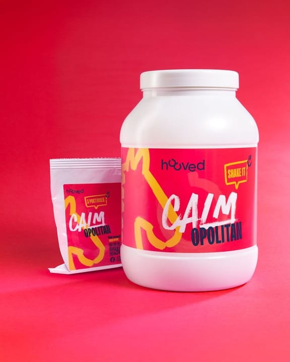 Weißer Proteinbehälter mit pinkem Etikett und weißem Deckel, daneben eine kleine Packung mit ähnlichem Design, auf pinkem Hintergrund.