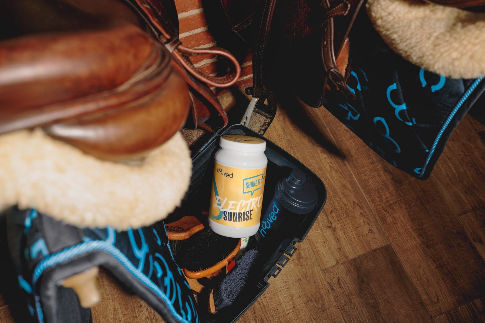 Blick in einen Rucksack mit verschiedenen Gegenständen, darunter eine Flasche mit blauer Beschriftung, eine Wasserflasche und Kleidung.