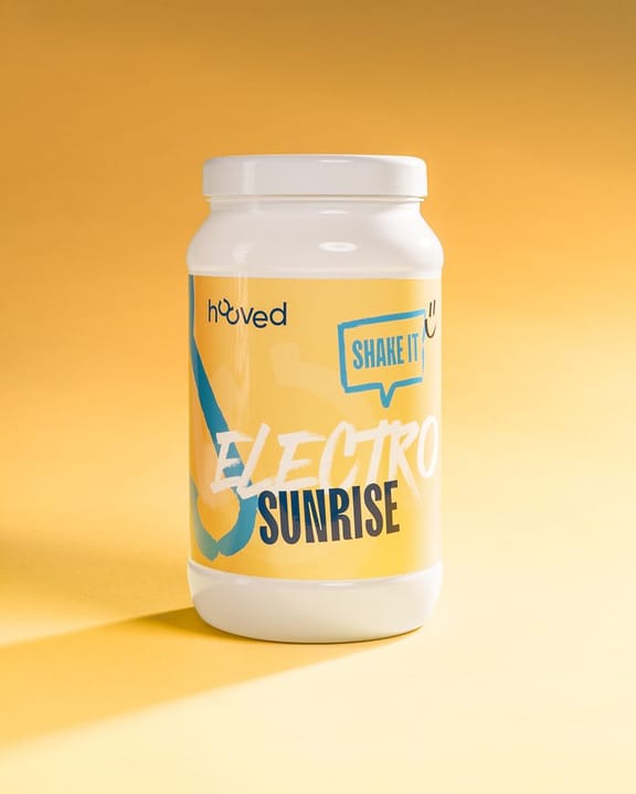 Weiße Protein-Dose mit gelber Etikette, blaue und weiße Schrift, Logo eines Pferdes, Produktname "Electro Sunrise" und Slogan "Shake It".