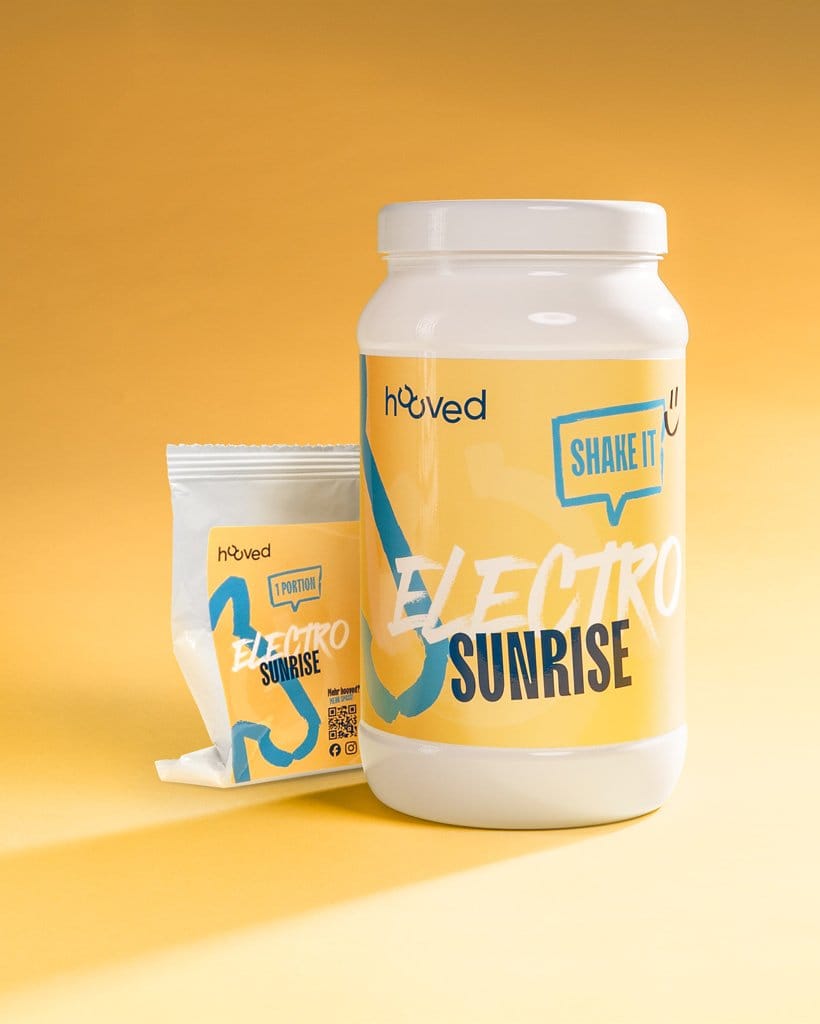 Weiße Dose und Packung mit blauer und gelber Verpackung, beides mit "Electro Sunrise" und "Shake It" Beschriftung, gegen den gelben Hintergrund.